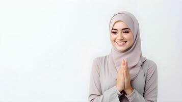 Arabic woman wearing scarf is praying and smiling on white background photo