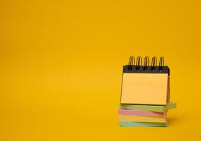 Stack of paper multi-colored stickers on a yellow background photo