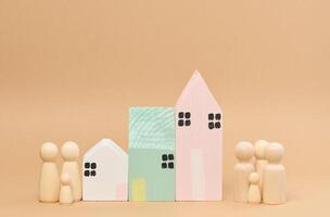 Wooden houses and wooden men of a family with children. Concept of searching for rental housing photo