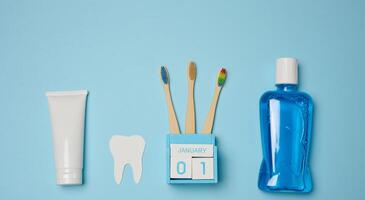 Mouthwash, toothpaste tube, dental floss on a blue background, oral hygiene. photo