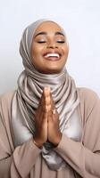 African woman wearing scarf is praying and smiling on white background photo