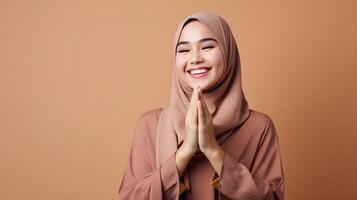 Sureste asiático mujer vistiendo bufanda es Orando y sonriente en marrón antecedentes foto