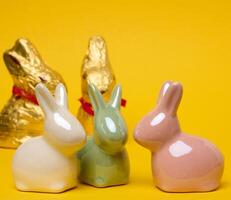 Ceramic decorative bunnies on a yellow background, festive Easter background photo