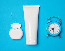 Toothpaste and dental floss on a blue background, top view photo