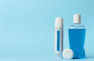 Mouthwash, toothpaste tube, dental floss on a blue background, oral hygien photo