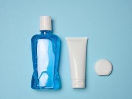 Mouthwash, toothpaste tube, dental floss on a blue background, oral hygiene photo