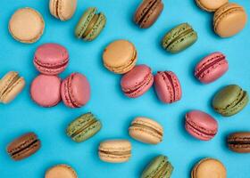 Multicolored macarons on a blue background, top view, dessert photo