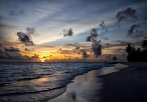 puesta de sol terminado el Oceano con nubes y montañas en el antecedentes foto