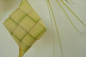 Ketupat isolated on white background. A typical Eid al-Fitr dish made from rice wrapped in a wrap made from woven young coconut leaves. typical Malay and Indonesian food photo