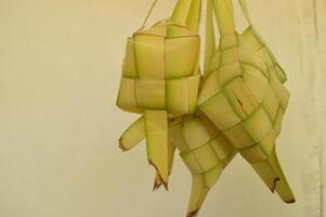 Ketupat isolated on white background. A typical Eid al-Fitr dish made from rice wrapped in a wrap made from woven young coconut leaves. typical Malay and Indonesian food photo