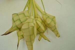 Ketupat isolated on white background. A typical Eid al-Fitr dish made from rice wrapped in a wrap made from woven young coconut leaves. typical Malay and Indonesian food photo