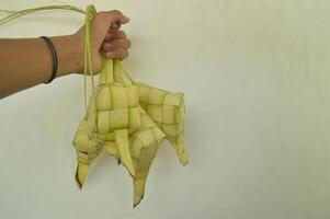 ketupat aislado en blanco antecedentes. un típico eid al-fitr plato hecho desde arroz envuelto en un envolver hecho desde tejido joven Coco hojas. típico malayo y indonesio comida foto