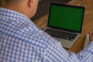 Cropped image of man working on a laptop at home photo