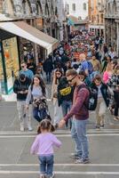 Venice, Italy - Italy 2, 2023. Crowds of tourists strolling on the cobblestone alley near Grand Canal in Venice. photo