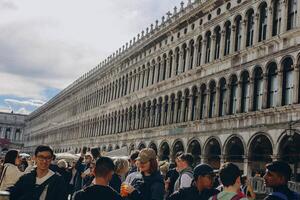 Venice, Italy - Italy 2, 2023. Crowds of tourists strolling on the cobblestone alley near Grand Canal in Venice. photo