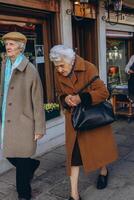 Rome, Italy-April 2, 2023.two retired women walking down a street in Rome. photo