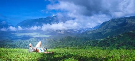 asiático mujer viaje relajarse en el día festivo. dormir relajarse en el césped en el montaña. en Tailandia foto