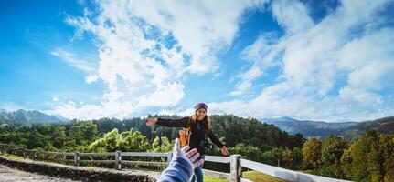 Pareja asiáticos viaje naturaleza en el día festivo. sostener manos corriendo contento disfrutar naturaleza en el montaña a oveja granja doi Pha Espiga en Tailandia foto