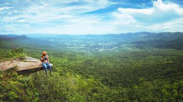 women asians travel relax in the holiday. Sit Take a photo on the cliff.