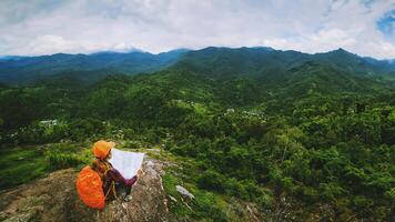 las mujeres asiáticas viajan relajarse en las vacaciones. ver mapa explorar las montañas foto