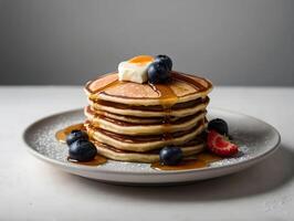 stack of pancakes with berries on a plate in grey background photo