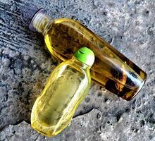 Olive oil in a bottle on moss grass background and plaster photo