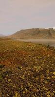 Clear river with rocks leads towards mountains lit by sunset video