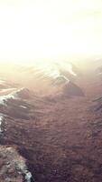 large snow patch left over on the volcanic rock field of a mountain in summer video