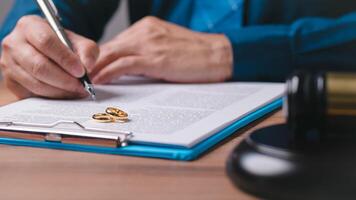 A man is writing on a piece of paper with a pen. concept for divorce, wean photo