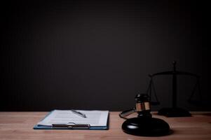 A judge's gavel sits on a desk next to a stack of papers. The scene is set in a courtroom, and the judge's gavel is a symbol of authority and order photo