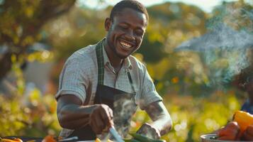 african man cooking outdoors smiling enjoying photo