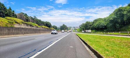 pavimentado la carretera con carros paso por en un soleado día en campinas foto