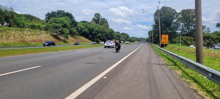 pavimentado la carretera con carros paso por en un soleado día en campinas foto