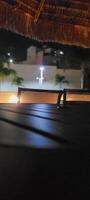 image of dark table in garden with pool at night photo