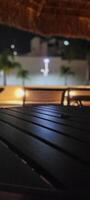 image of dark table in garden with pool at night photo