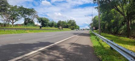 paved road with cars passing by on a sunny day in campinas photo