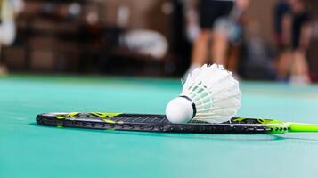 White badminton shuttlecocks and badminton rackets on green floor indoor badminton court soft and selective focus on shuttlecocks and the rackets photo