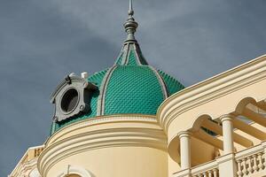 the facade of a famous building in Monaco with a picturesque green dome in clear sunny weather photo