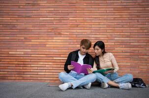 Group of young interracial diverse university students reading textbook and sitting outside a classroom under a building, engaging in a discussion together, college campus, enjoying campus recreation. photo