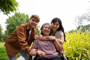 Asian careful caregiver or nurse taking care of the patient in a wheelchair. Concept of a happy retirement with care from a caregiver and Savings and senior health insurance, a Happy Family photo