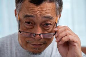 Senior Man Squinting Eyes and Take off put on glasses, Having Problems With Vision, Ophthalmic Issue, Bad Sight In Older Age, wearing eyeglasses posing against looking with wide opened eyes photo