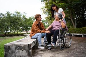 asiático Cuidado cuidador o enfermero tomando cuidado de el paciente en un silla de ruedas. concepto de un contento Jubilación con cuidado desde un cuidador y ahorros y mayor salud seguro, un contento familia foto