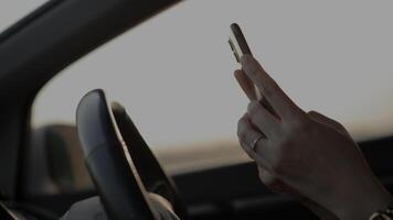 Hand using phone in car at sunset in summer, travel concept video