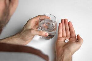 A man holds in his hand a portion of pills for treatment. photo