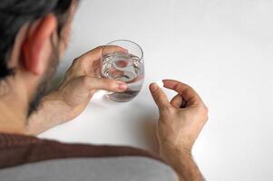 A man holds in his hand a portion of pills for treatment. photo