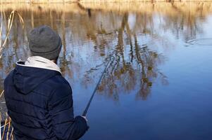 pescar varilla en el manos de un pescador en el lago. foto