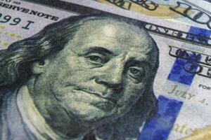 Benjamin Franklin's face on the US 100 dollar bill. Closeup of Ben Franklin on a one hundred dollar bill. Benjamin Franklin portrait from hundred dollar bill macro photo