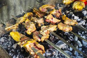 A lot of kebab skewers on the grill, on the coals close-up in the smoke photo