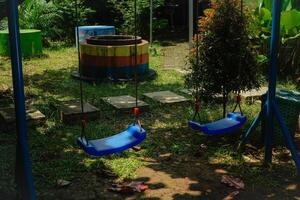 A close-up view of two swings tied between the trees, the concept of a children's play area. photo