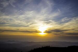 Dramatic sunset sky over rolling mountains photo